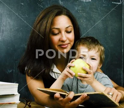 Little cute boy in glasses with young real teacher, classroom studying Stock Photos