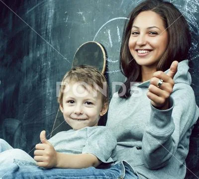 Little cute boy in glasses with young real teacher, classroom studying Stock Photos