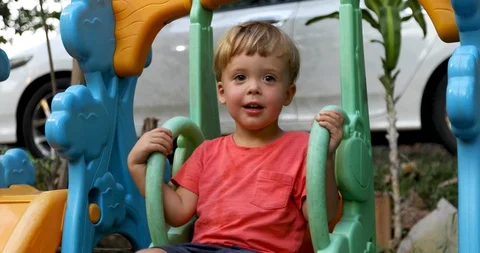 Little cute boy having fun on swings Stock Footage 102660557