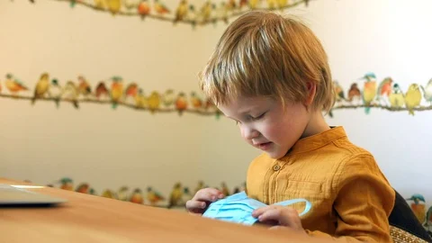 Little cute boy learning how to wear protective face mask at home spending time 스톡 동영상 128236785