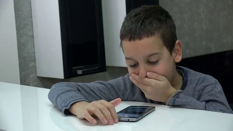 Little cute boy looking surprised into the smartphone screen Vídeo Stock 82213426