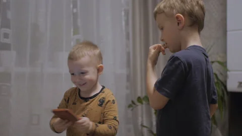 Little cute boy nervously biting nails, his small brother nearby Video stock 156018402
