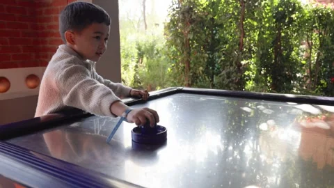 Little cute boy plays a table hockey Stock Footage 244635330