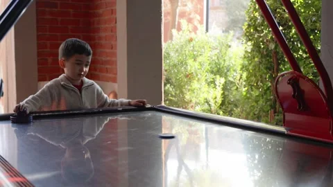 Little cute boy plays a table hockey Stock Footage 244828799