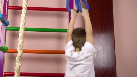 A little cute boy of three years old goes in for sports on gymnastic rings.It Stockbeeldmateriaal 149276489