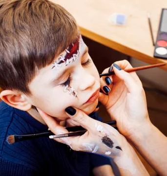 Little cute child making facepaint on birthday party, zombie Apo Stock Photos