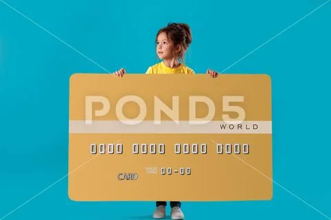 Little cute girl holding big gold credit card Stock Photos