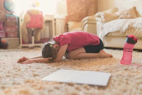 Little cute girl is practicing gymnastics at home. Online traini Stock Photos