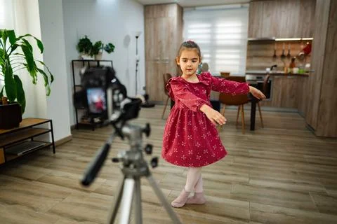 Little dancer performs gracefully in a cozy home space while being filmed for a Stock Photos