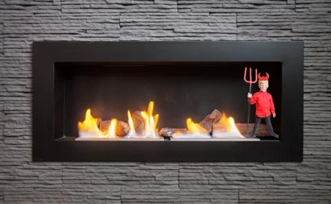 Little devil in the modern fireplace. Stock Photos