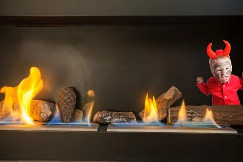Little devil in the modern fireplace. Stock Photos