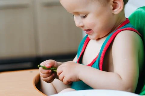Little eats peas in the kitchen Stock Photos