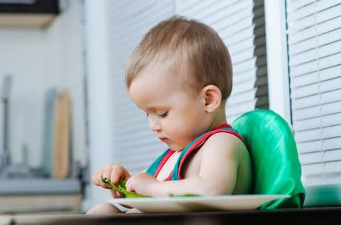 Little eats peas in the kitchen Stock Photos
