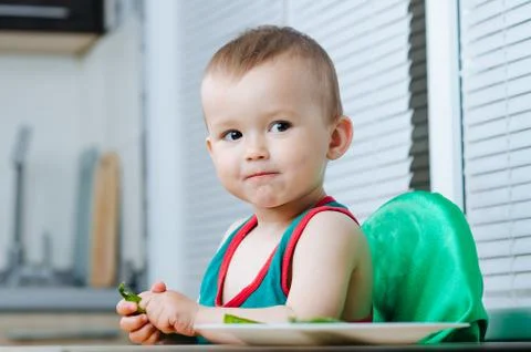 Little eats peas in the kitchen Stock Photos