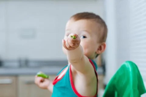 Little eats peas in the kitchen Stock Photos