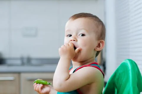 Little eats peas in the kitchen Stock Photos