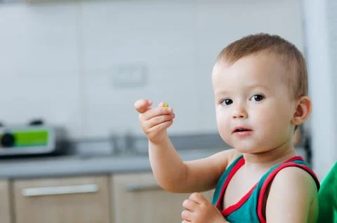Little eats peas in the kitchen Stock Photos