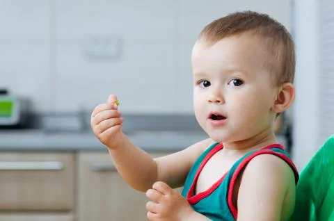 Little eats peas in the kitchen Stock Photos