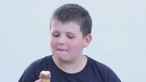 Little fat boy eats ice cream on the street. Satisfied facial expression. Stock Footage 197431011
