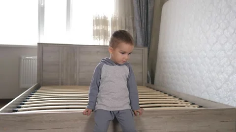 Little fathers assistant is waving to camera and sitting on the wooden slots of Stock Footage 220143513