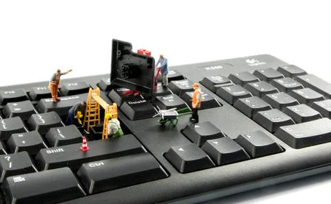Little figures try to hack the computer system Stock Photos