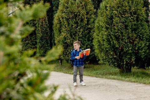 Little first grader with backpack looking the copybook, going home from schoo Stock Photos