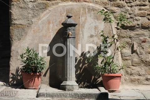 Little fountain in a medieval Italian town. Stock Photos