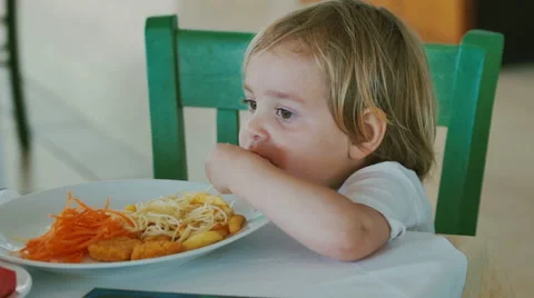 Little funny kid eats spaghetti by hands. Stock Footage 63790450