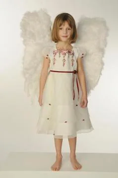 Little girl (6-7) wearing angel wings Stock Photos