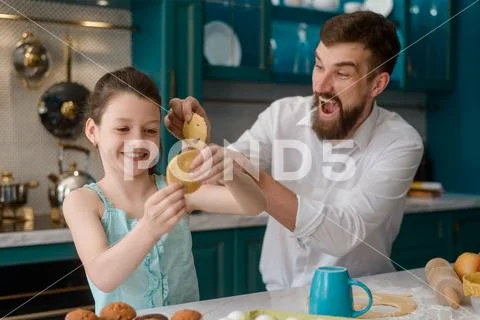 Little girl and her dad playing in the kitchen Stock Photos