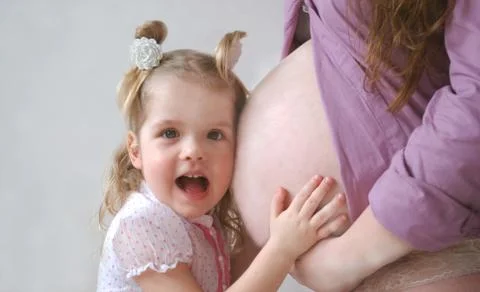 Little girl and pregant mom Stock Photos