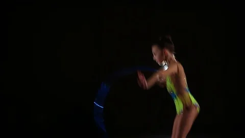 Little girl athlete performs elements of rhythmic gymnastics with hoop in gym Stock Footage 104126620