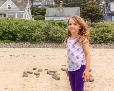 Little girl on the beach strong as the ocean Stock Photos