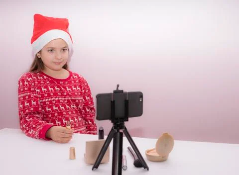 Little girl blogger, influence, in a Christmas hat Stock Photos