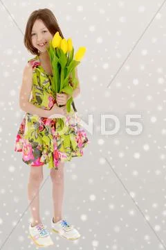 Little girl with a bouquet of yellow tulips. Stock Photos