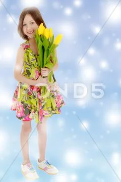 Little girl with a bouquet of yellow tulips. Stock Photos
