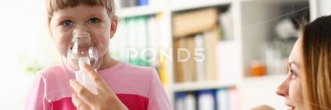 Little girl breathing with inhaler at doctor office Stock Photos