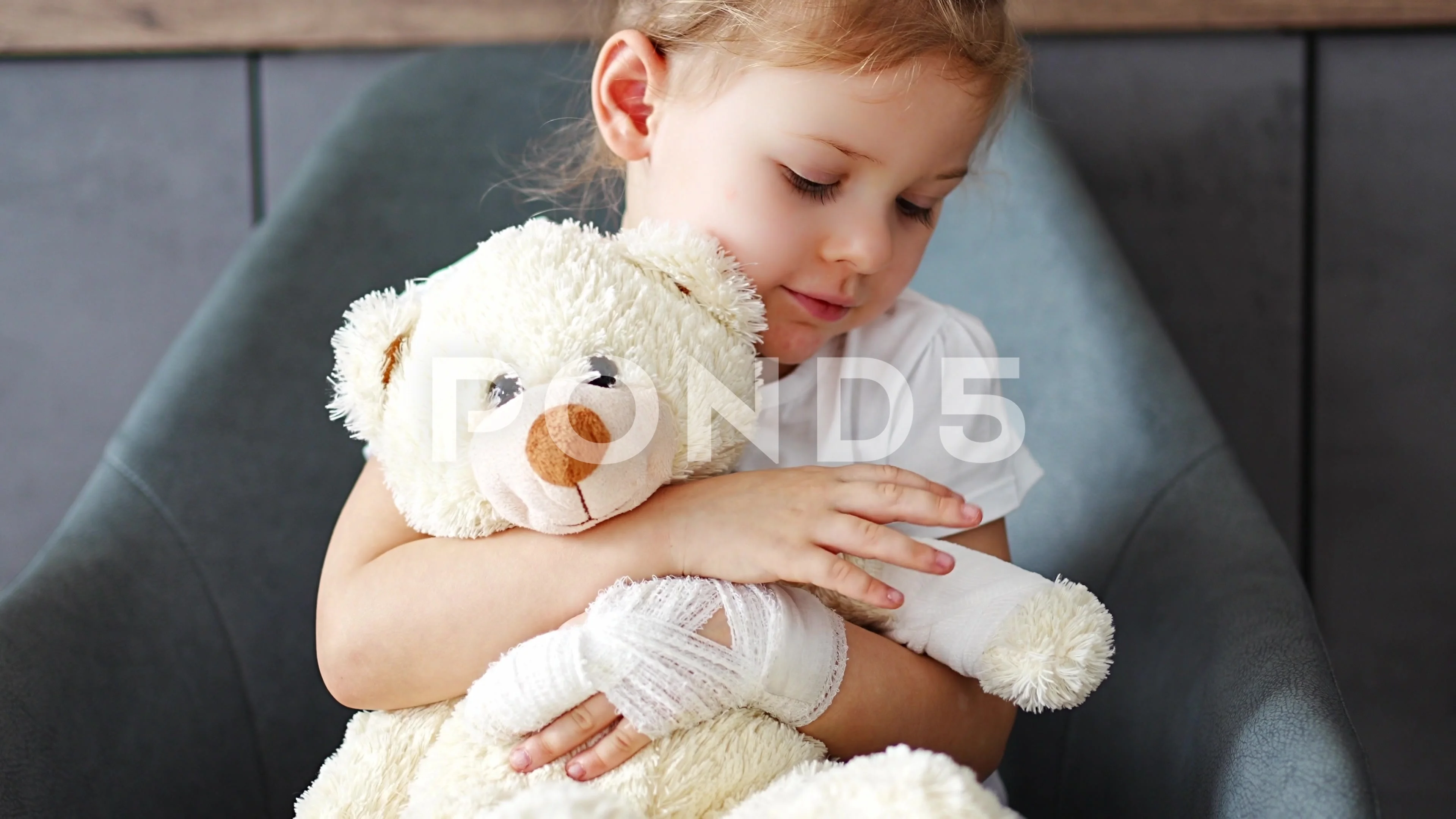 Cute little girl with broken arm in the gypsum with teddy bear