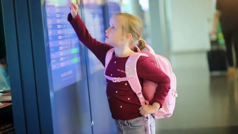 Little girl checking flight information screen at airport Stock Footage 315536616