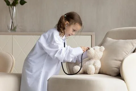 Little girl child play doctor with toy at home Stock Photos