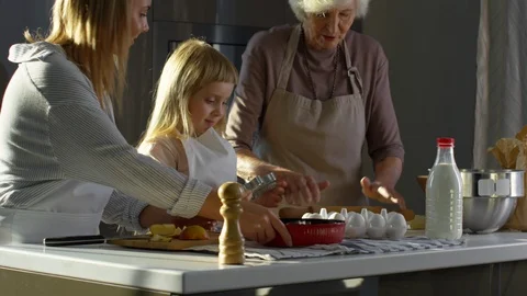 Little Girl Cooking with Mom and Grandma | Stock Video - Pond5 