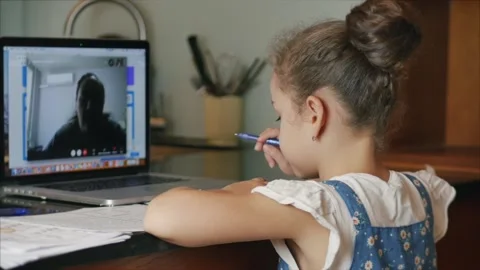 Little girl a cute elementary school child of 7-8 years old at home studying in Vidéo 142903473