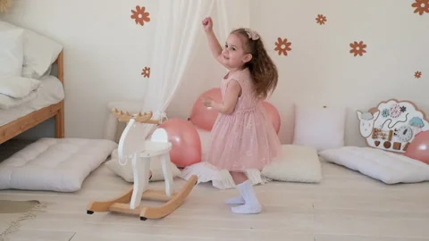 A little girl is dancing in the room while celebrating her birthday Stock Footage 240120136