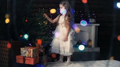 Little girl decorates the Christmas tree Stockbeeldmateriaal 94443353