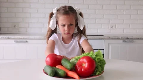 The little girl does not want to eat vegetables. Child gets angry and turns away Stock Footage 138987553