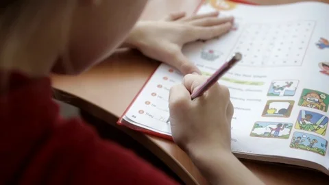 Little girl does test tasks in a notebook Stock Footage 90868569