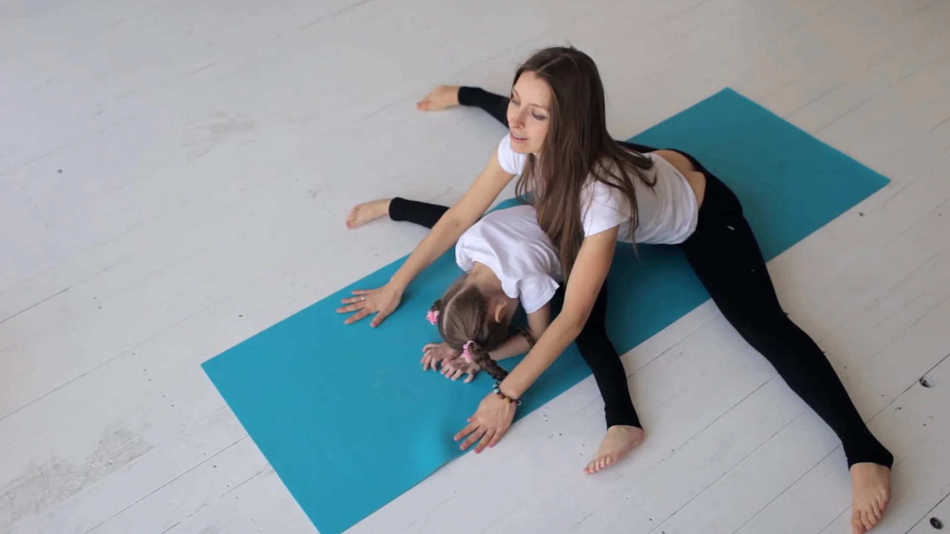 little girl doing yoga with her mom in t, Stock Video