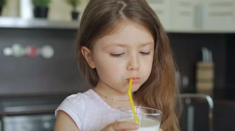 Little girl drinking milk through a stra... | Stock Video | Pond5