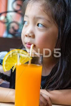 Little Girl Drinking Orange Juice