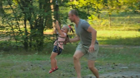 Little girl drives on ropeway in rope park Stock Footage